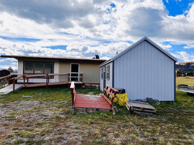 back of property featuring a deck and a yard