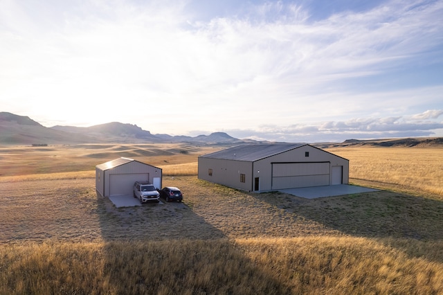 exterior space featuring a mountain view, an outdoor structure, a rural view, and a garage