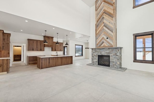 unfurnished living room with a stone fireplace and a towering ceiling