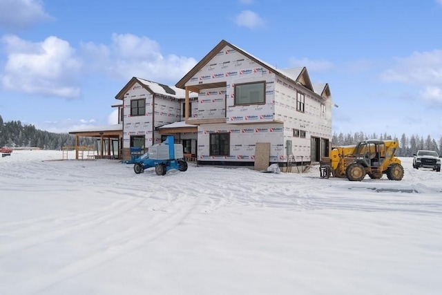 view of snow covered back of property