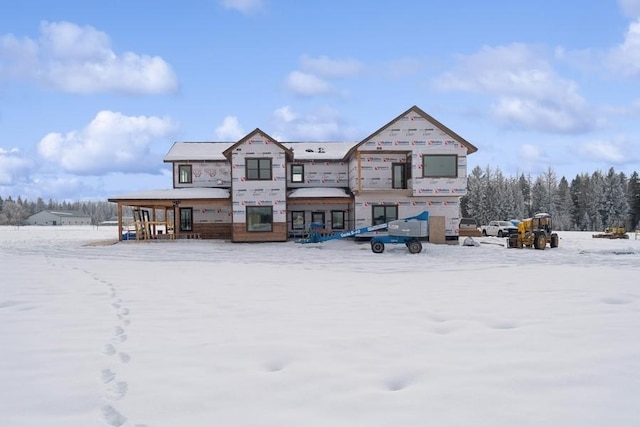 view of snow covered back of property