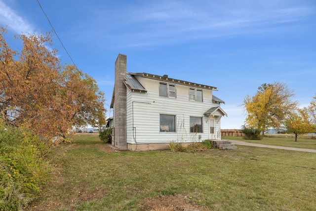 rear view of house featuring a yard