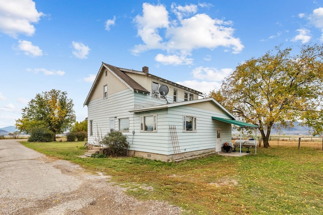 view of side of home with a lawn