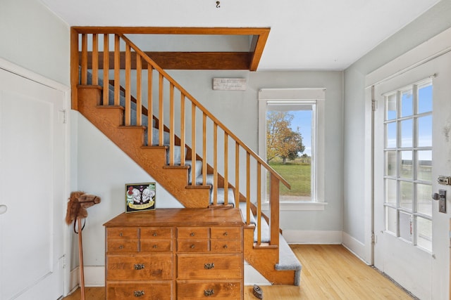 stairway with light hardwood / wood-style floors