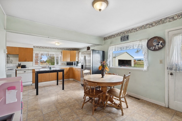 dining area with light tile floors and sink