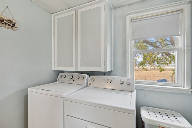 washroom featuring cabinets and separate washer and dryer