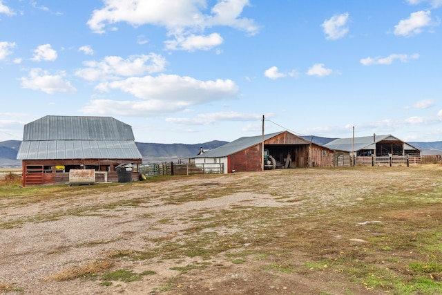 view of yard featuring a rural view, an outdoor structure, and a mountain view