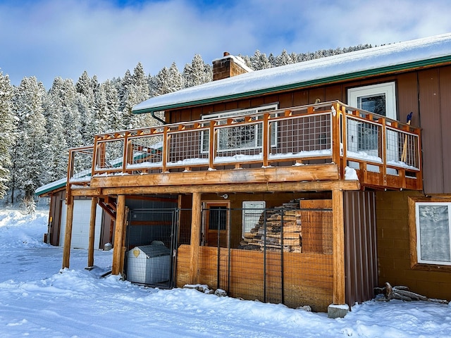 425 Lagger Gulch Rd, Anaconda, MT 59711 - snow covered house with board and batten siding, a chimney, and a wooden deck