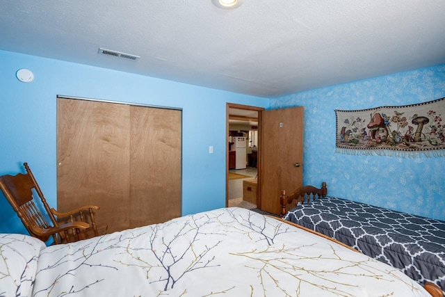 425 Lagger Gulch Rd, Anaconda, MT 59711 - bedroom featuring freestanding refrigerator, a closet, visible vents, and wallpapered walls