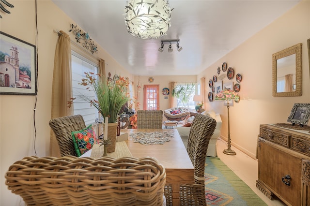 dining room with baseboards and rail lighting