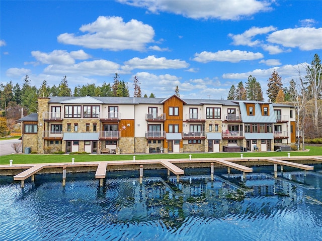 back of property featuring a yard and a water view