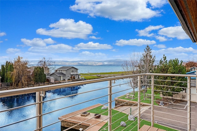 balcony featuring a water and mountain view