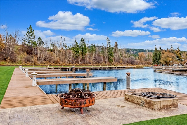 view of dock with a fire pit and a water view