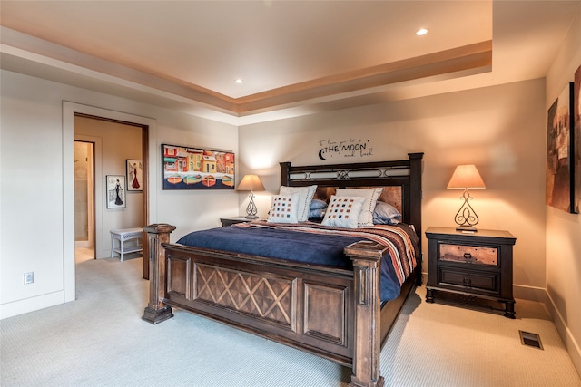 carpeted bedroom featuring a raised ceiling