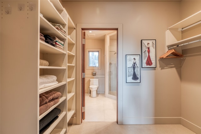 walk in closet with light tile patterned floors