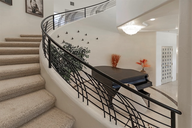 staircase with a chandelier