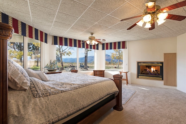 bedroom with ceiling fan, carpet flooring, and a mountain view