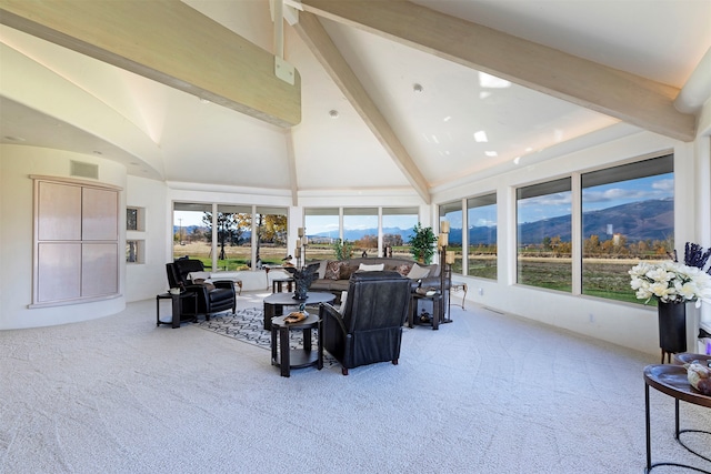 carpeted living room with beamed ceiling and high vaulted ceiling