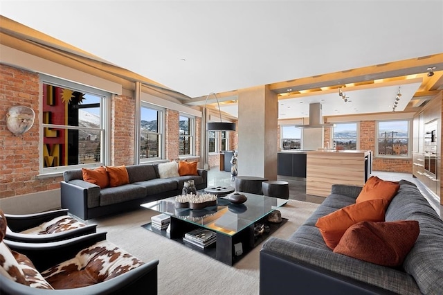 living room featuring an inviting chandelier and brick wall