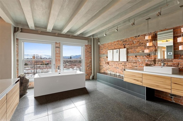 bathroom featuring brick wall, beamed ceiling, vanity, and a tub