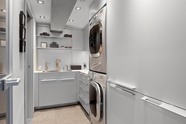 laundry area with stacked washer / dryer and sink