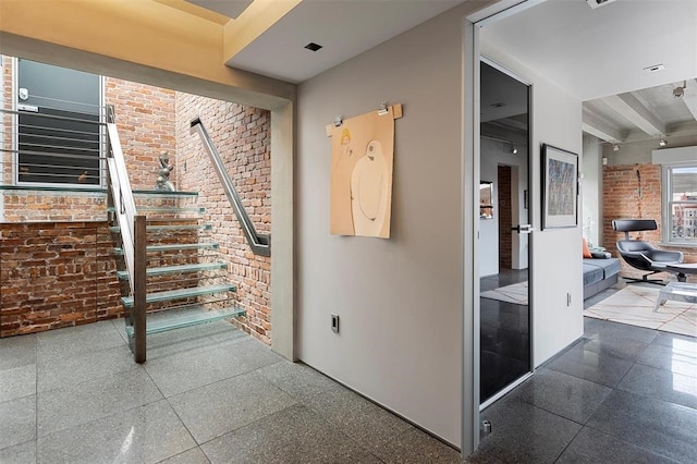 interior space featuring brick wall and beam ceiling