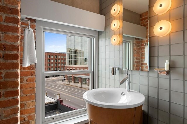 bathroom featuring vanity and tile walls