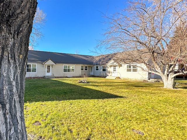 rear view of house featuring a lawn