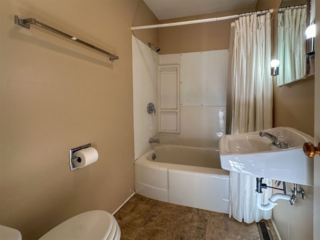 bathroom featuring tile floors, toilet, and shower / tub combo with curtain