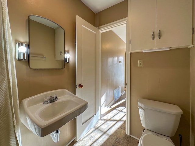 bathroom with toilet, tile floors, and sink