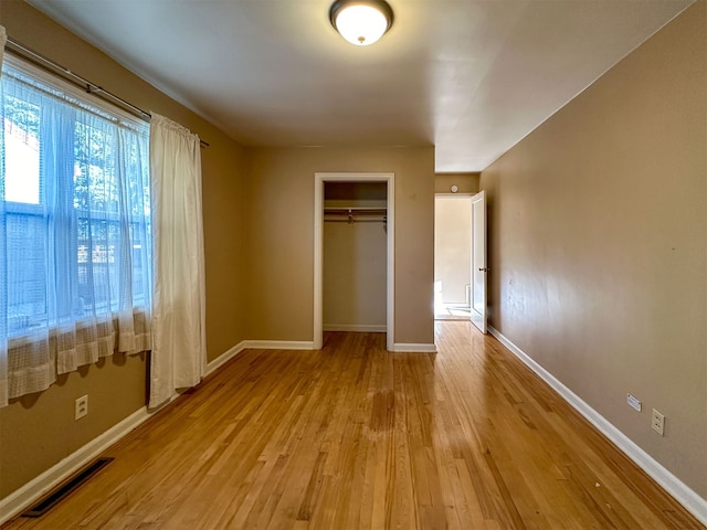 unfurnished bedroom with a closet and light hardwood / wood-style floors