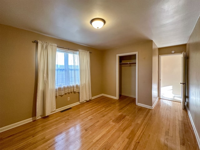 unfurnished bedroom featuring a closet and light wood-type flooring