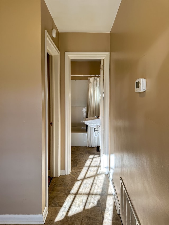 corridor featuring dark tile flooring