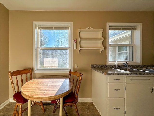 tiled dining area featuring a healthy amount of sunlight and sink