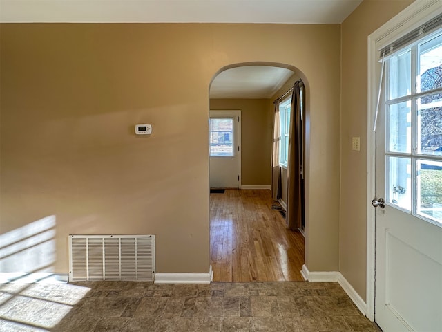 interior space featuring dark tile flooring and a healthy amount of sunlight