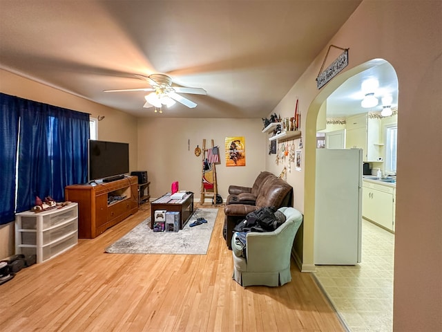 living room with light hardwood / wood-style flooring and ceiling fan with notable chandelier