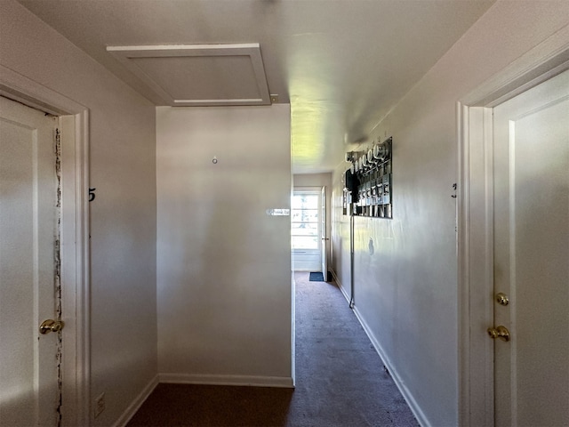 hall with dark colored carpet