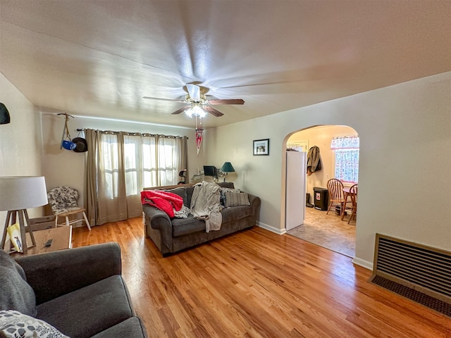 living room with light hardwood / wood-style flooring, plenty of natural light, and ceiling fan