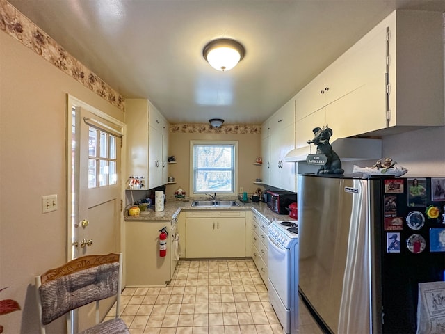 kitchen with light tile flooring, stainless steel refrigerator, white stove, sink, and white cabinetry