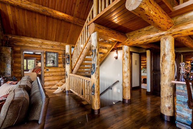 staircase with beamed ceiling, wood-type flooring, rustic walls, and wooden ceiling