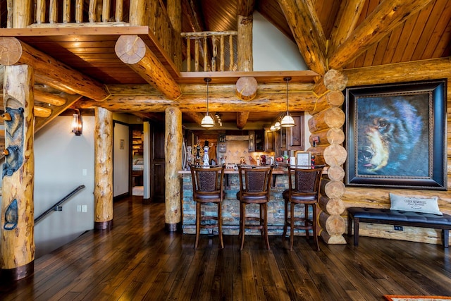 bar with log walls, dark wood-style floors, and a bar