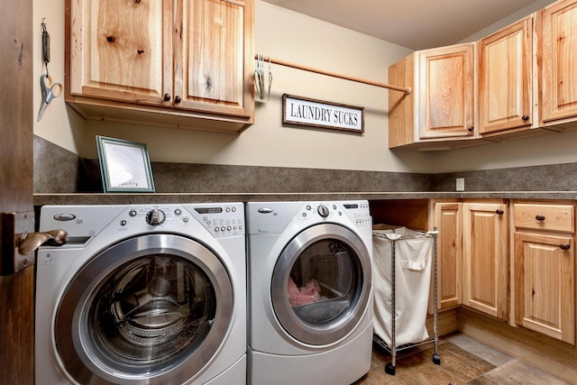 clothes washing area with separate washer and dryer, cabinet space, and wood finished floors