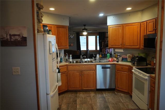 kitchen with dark tile flooring, stainless steel appliances, ceiling fan, and sink