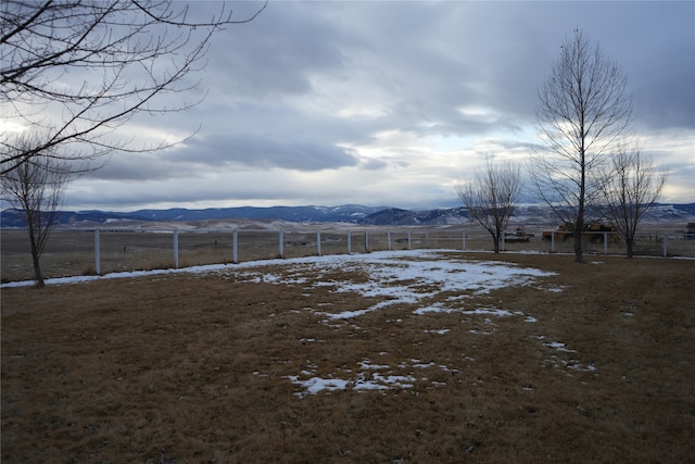 view of yard with a rural view and a mountain view