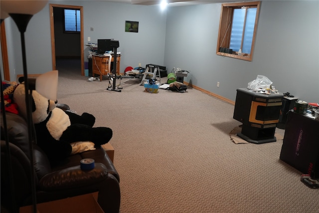 recreation room with carpet flooring and a wood stove