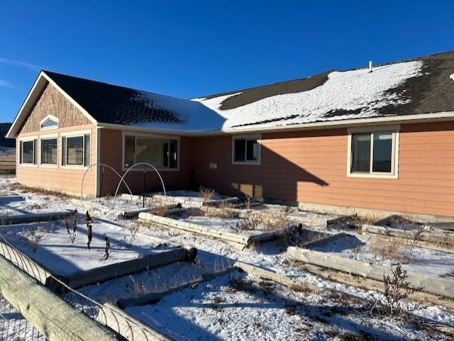 view of snow covered back of property