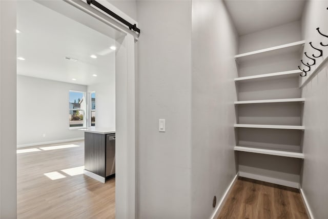 hallway featuring hardwood / wood-style flooring and a barn door