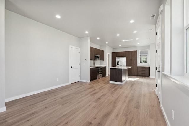 kitchen featuring dark brown cabinetry, light hardwood / wood-style flooring, appliances with stainless steel finishes, and a kitchen island