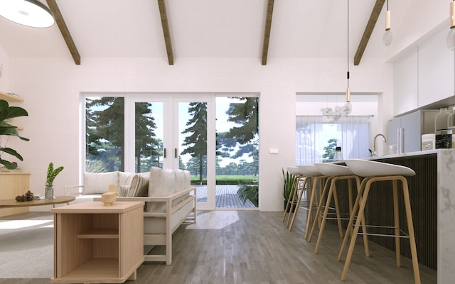 unfurnished living room with light wood-type flooring, beam ceiling, plenty of natural light, and sink