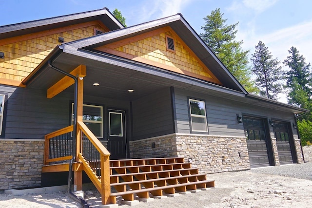 exterior space featuring a garage, stone siding, and driveway